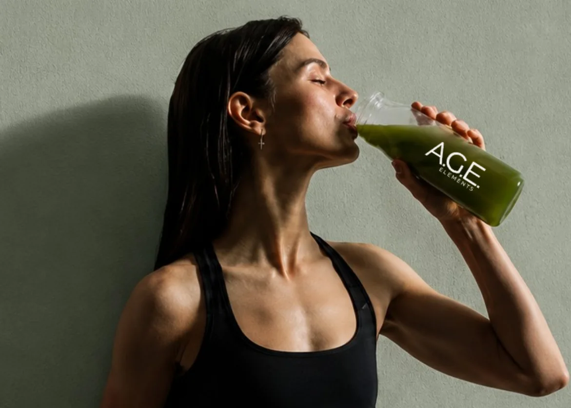 Frau trinkt A.G.E. Elements aus der Glasflasche
