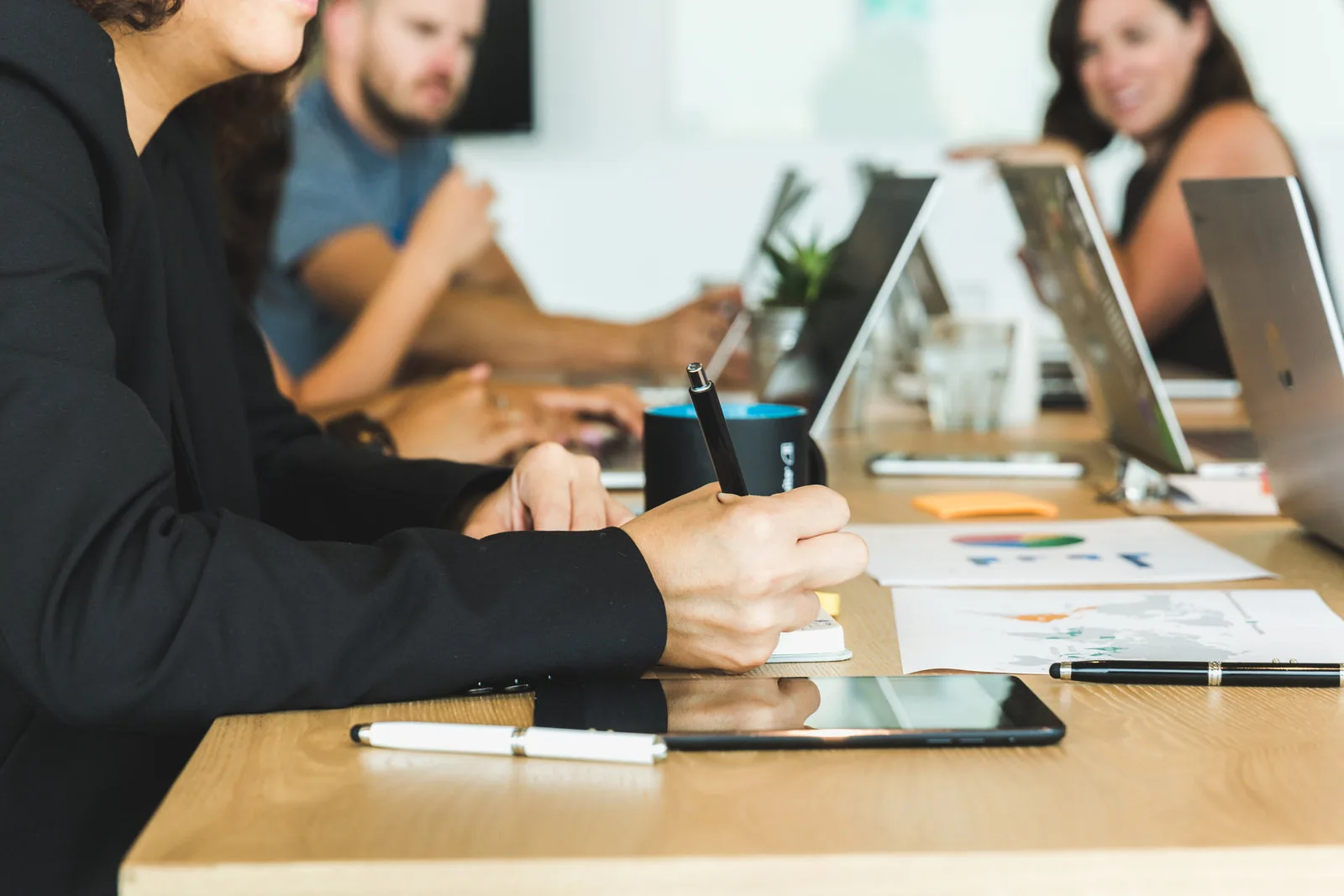 Frau macht sich Notizen in einem Team-Meeting